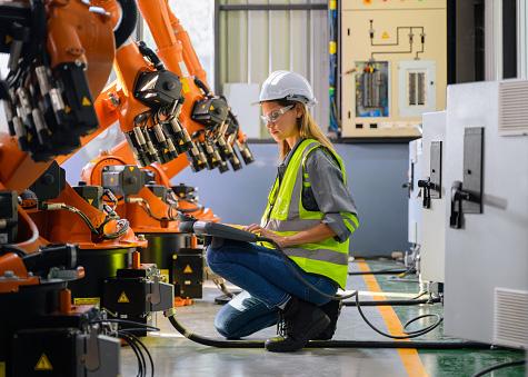 Female engineer worker working with robotic machine automation