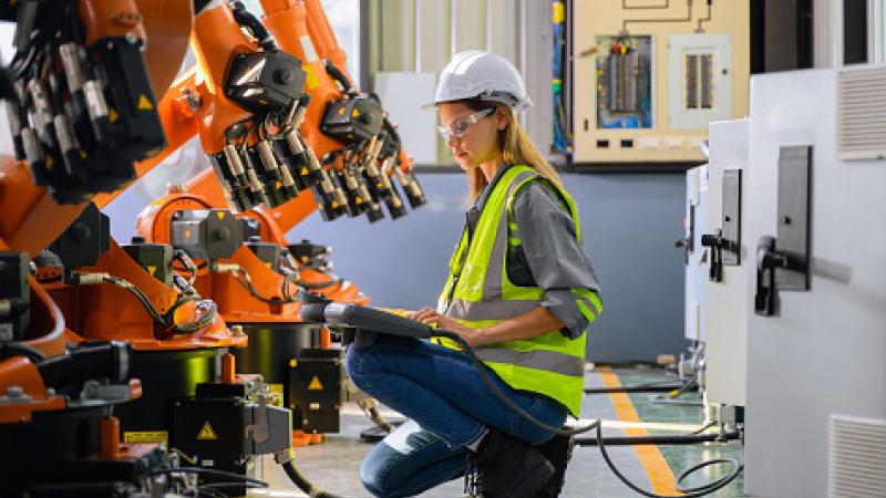 Female engineer worker working with robotic machine automation